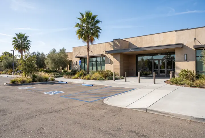 A row of accessible parking stalls with blue painted striping and a hatched access aisle beside them