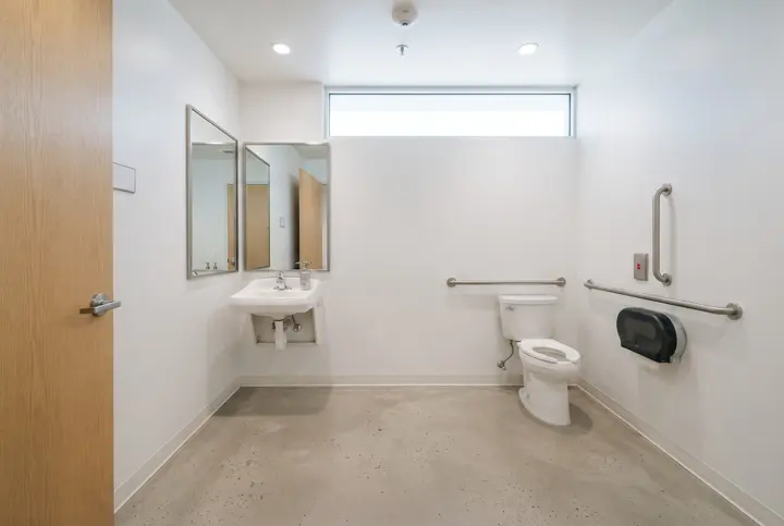 A single-user accessible restroom with a wide open floor