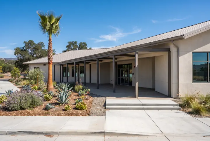 A single-story school administration building with light stucco walls