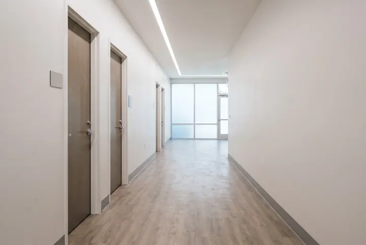A renovated commercial corridor with new light wood-look vinyl plank flooring