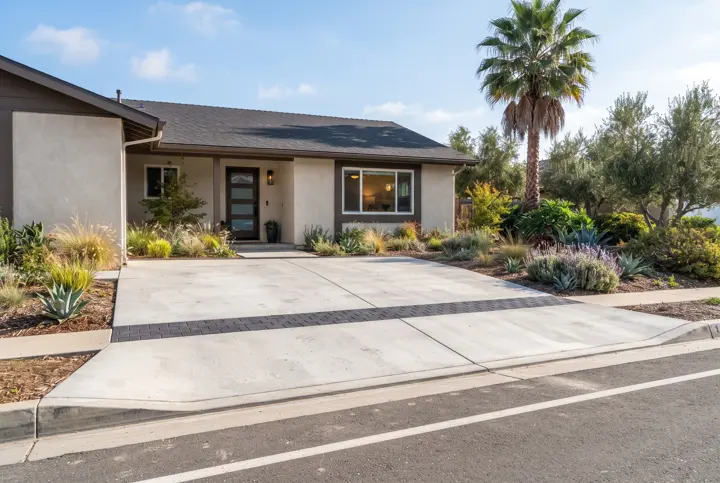 A new light concrete driveway apron meeting a residential street