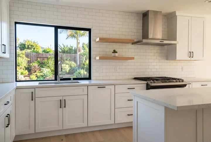 White kitchen with subway tile, open wood shelves and a stainless range hood under a garden window
