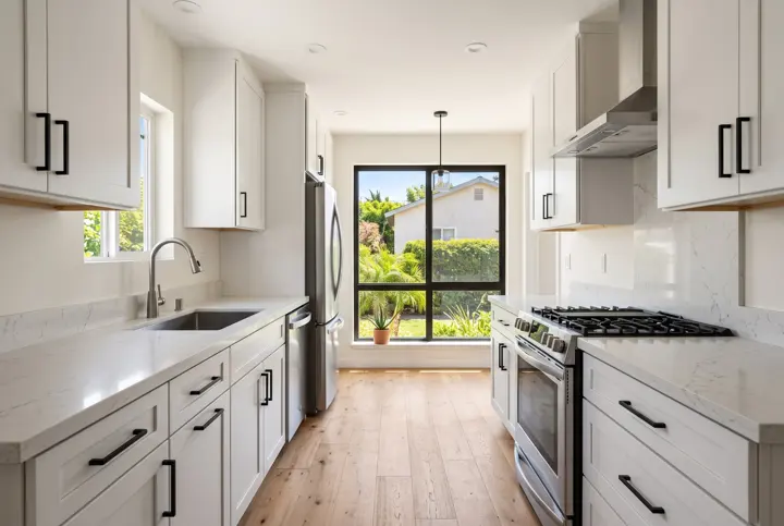 Galley kitchen with a black-framed window and garden view at the end