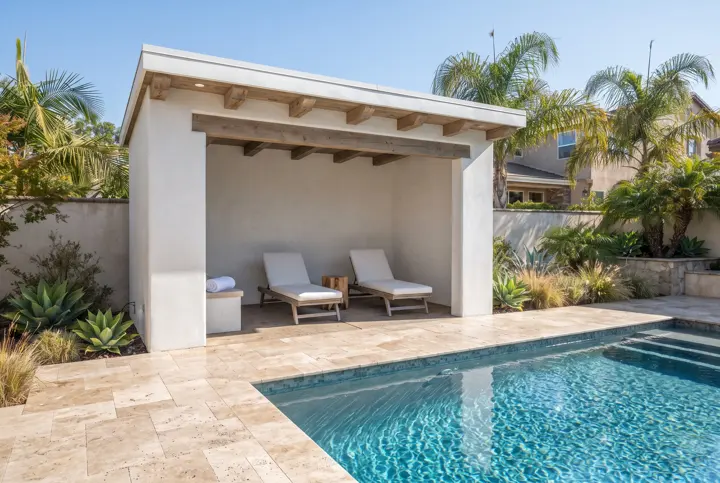 A poolside cabana with a white stucco and wood-beam structure, a sheer-curtain-free open front