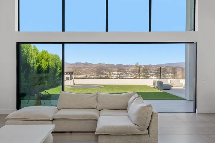 Living room with a wall of sliding glass doors opening to the backyard lawn, interior renovation in Santa Clarita, CA, photo 5