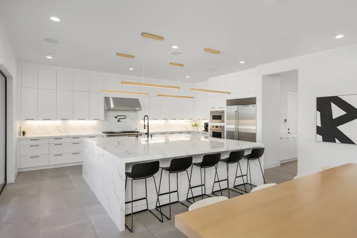 Chef's kitchen with a large white stone island, bar stools and white cabinetry, kitchen remodel in Santa Clarita, CA, photo 9