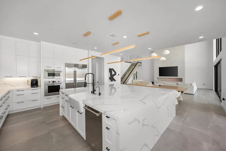 Kitchen island with a veined white stone counter and built-in ovens behind, kitchen remodel in Santa Clarita, CA, photo 10