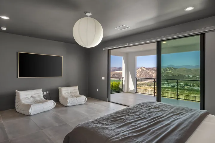 Primary suite sitting area with a wall-mounted TV and balcony views, interior design in Santa Clarita, CA, photo 16