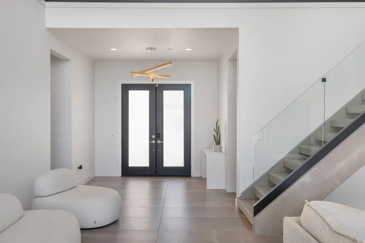 Entry foyer with glass double doors and a floating staircase, interior renovation in Santa Clarita, CA, photo 24