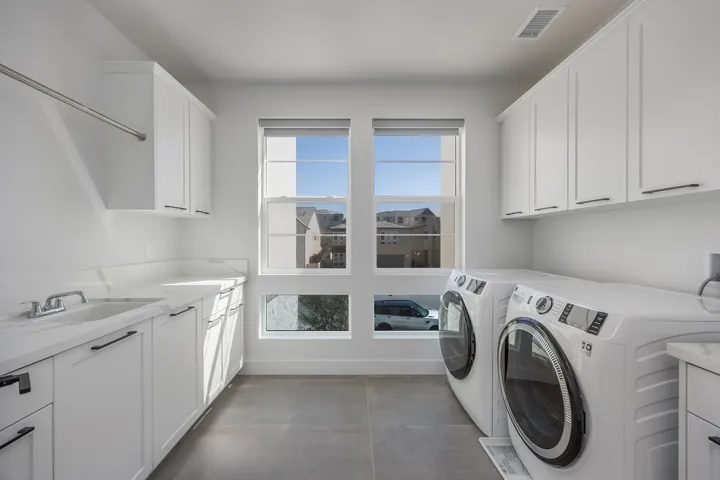 Laundry room with white cabinetry, a utility sink and a front-load washer and dryer, interior renovation in Santa Clarita, CA, photo 29