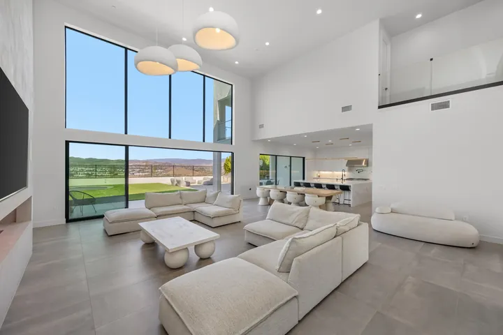 Open great room with floor-to-ceiling windows, white sectional seating and a view into the kitchen, interior renovation in Santa Clarita, CA, photo 3