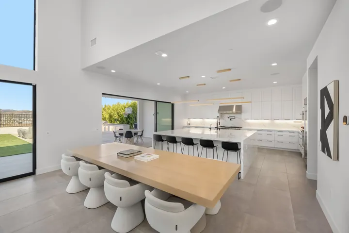 Wide view of the kitchen island, wood dining table and sliding glass doors to the yard, interior design in Santa Clarita, CA, photo 8