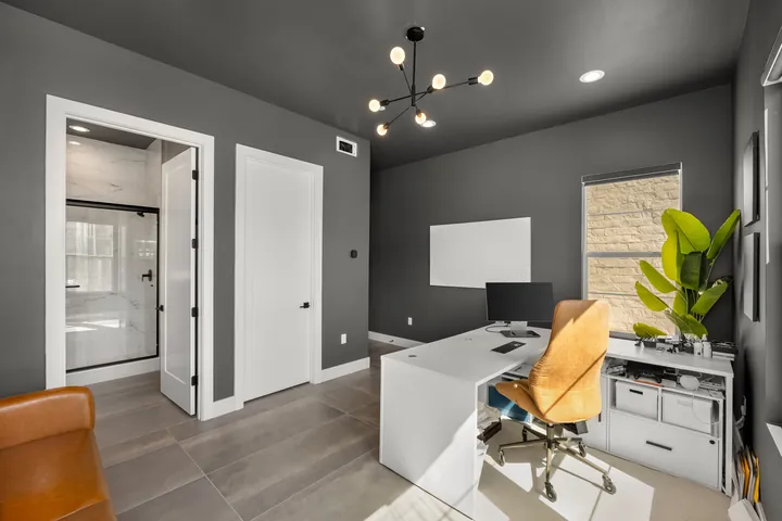 Home office seen from the door with charcoal walls, a modern black chandelier and a white desk, interior design in Santa Clarita, CA, photo 13
